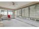 Enclosed sunroom featuring multiple windows with views of the outdoors and a ceiling fan at 30653 Pga Dr, Sorrento, FL 32776