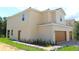 Well-maintained two-story home with lush landscaping, side door, and two-car garage at 575 Bay Leaf Dr, Poinciana, FL 34759
