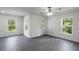 Spacious living room featuring modern gray floors, a ceiling fan and lots of windows at 575 Bay Leaf Dr, Poinciana, FL 34759