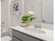 Modern bathroom featuring a quartz countertop, gray vanity and decorative flower arrangement at 612 Terrapin Dr, Debary, FL 32713