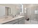 Bright bathroom featuring double sinks, a glass-enclosed shower, and lots of natural light at 614 Terrapin Dr, Debary, FL 32713