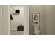 Contemporary half-bath with modern toilet, neutral walls, stylish artwork, and a small closet for storage at 698 Peroni Ave, Debary, FL 32713