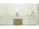 All-white bathroom with double vanity, mirrors, and a seated makeup area under the window at 703 Peroni Ave, Debary, FL 32713