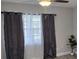 Cozy bedroom features modern curtains and light fixture, and neutral paint at 917 Adamson Ct, Lake Alfred, FL 33850
