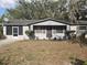 Well-maintained single-story home with a gray exterior, front yard, and landscaping at 917 Adamson Ct, Lake Alfred, FL 33850