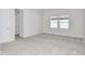A bright bedroom featuring plush carpet, large windows, and a walk-in closet at 1411 Hamilton Way, Lake Alfred, FL 33850