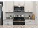 Kitchen features granite countertops, stainless steel appliances, white cabinetry, and center island at 14404 Sw 19Th Pl, Ocala, FL 34481
