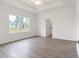 Bright main bedroom featuring a trey ceiling, a window, and wood-style flooring at 14404 Sw 19Th Pl, Ocala, FL 34481