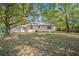A view of the backyard of a one story home surrounded by trees at 406 W Valencia St, Lakeland, FL 33805