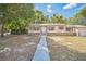 Charming single-story home with a classic design and a well-maintained yard and a long concrete walkway to the front door at 406 W Valencia St, Lakeland, FL 33805