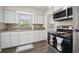 A bright kitchen featuring white cabinets, granite countertops, stainless steel appliances and stylish backsplash at 406 W Valencia St, Lakeland, FL 33805