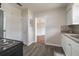 Open-concept kitchen featuring stainless appliances, tile backsplash, wood floor and seamless flow into the adjacent room at 406 W Valencia St, Lakeland, FL 33805
