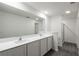 Bright bathroom with double sink vanity, a large mirror, and a glass shower stall at 587 Bay Leaf Dr, Poinciana, FL 34759