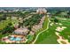 Expansive aerial view of a community with a large pool, golf course, and luxurious condominiums at 7673 Heritage Crossing Way # 202, Reunion, FL 34747