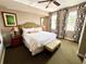 Bedroom with king bed, decorative headboard, bench, and large windows at 7673 Heritage Crossing Way # 202, Reunion, FL 34747