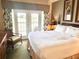 Comfortable bedroom with a plush bed, tropical decor, and access to a private balcony at 7673 Heritage Crossing Way # 202, Reunion, FL 34747