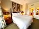 Comfortable bedroom features a king bed, lamps and paintings on the walls at 7673 Heritage Crossing Way # 202, Reunion, FL 34747