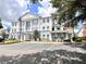 Exterior view of blue and white condominium building with ample parking at 7673 Heritage Crossing Way # 202, Reunion, FL 34747