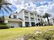 Exterior shot of a multi-story building with lawn, palm trees, and patios at 7673 Heritage Crossing Way # 202, Reunion, FL 34747