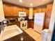 Functional kitchen featuring light wood cabinets, granite countertops, and modern white appliances at 7673 Heritage Crossing Way # 202, Reunion, FL 34747