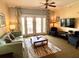 Cozy living room featuring a comfortable sofa, modern television, and decorative ceiling fan at 7673 Heritage Crossing Way # 202, Reunion, FL 34747