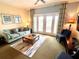 Inviting living room with stylish furniture, a patterned rug, and access to the balcony through glass doors at 7673 Heritage Crossing Way # 202, Reunion, FL 34747