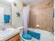 Tiled bathroom with a combined tub and shower, single sink, and decorative accents at 2138 Mirasol Dr, Winter Haven, FL 33881