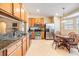 Open kitchen featuring stainless steel appliances, wood cabinets, granite countertops, and tiled floor at 2138 Mirasol Dr, Winter Haven, FL 33881