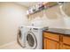 Well-equipped laundry room featuring modern washer, dryer, storage shelf, and granite countertop at 2138 Mirasol Dr, Winter Haven, FL 33881