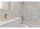 Bright bathroom features a white vanity with quartz counters and a shower with marbled tile surround at 2686 Sw 144Th Ct, Ocala, FL 34481