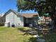 The backyard showcases healthy green grass, mature trees offering shade, and a home with a covered entrance at 400 Sw 1St Ave, Mulberry, FL 33860