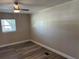 This bedroom offers wood-look flooring, a ceiling fan and natural light through a window at 400 Sw 1St Ave, Mulberry, FL 33860