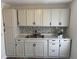 Modern kitchen featuring white cabinets, stainless steel appliances, and stylish backsplash at 400 Sw 1St Ave, Mulberry, FL 33860