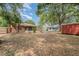View of the backyard showing the shed, screened in patio, and mature trees at 1313 Periwinkle Ct, Lakeland, FL 33811