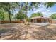 Wide shot of the backyard with patio, shed, trees, and partial fencing on a sunny day at 1313 Periwinkle Ct, Lakeland, FL 33811