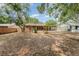 Spacious backyard with a screened-in patio, shed, mature trees, and partial fencing at 1313 Periwinkle Ct, Lakeland, FL 33811