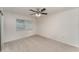 Bright bedroom features neutral carpet, a ceiling fan, and a window with horizontal blinds at 1313 Periwinkle Ct, Lakeland, FL 33811