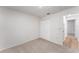Neutral carpeted bedroom featuring a double-door closet and a doorway with hardwood floors just beyond at 1313 Periwinkle Ct, Lakeland, FL 33811