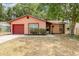 Charming single-story home with a well-maintained lawn and a red garage door at 1313 Periwinkle Ct, Lakeland, FL 33811