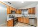 Modern kitchen with stainless steel appliances, wood cabinets, and ample countertop space at 1313 Periwinkle Ct, Lakeland, FL 33811