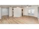 Spacious living area with light-colored wood floors, open to the kitchen and patio doors at 1313 Periwinkle Ct, Lakeland, FL 33811