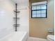Clean bathroom features a tiled shower-tub combo and convenient corner shelving unit at 713 W 3Rd St, Lakeland, FL 33805