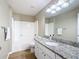 Bathroom featuring granite countertops, modern vanity lights, and a shower-tub combo at 1639 Saddlehorn Dr, Lakeland, FL 33810