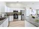 Bright kitchen featuring stainless steel appliances, granite countertops, and white cabinets at 1639 Saddlehorn Dr, Lakeland, FL 33810