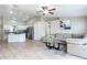 Open-concept living room adjacent to the kitchen, featuring a comfortable sofa, modern decor, and wood floors at 1639 Saddlehorn Dr, Lakeland, FL 33810