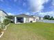 A well-maintained backyard with lush green grass, a patio, and a white fence at 3205 Royal Tern Dr, Winter Haven, FL 33881