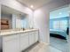 A modern bathroom featuring a double vanity with a white countertop and neutral walls with tile flooring at 3205 Royal Tern Dr, Winter Haven, FL 33881