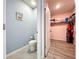 A bathroom and walk in closet feature blue walls, a toilet, and shelving at 3205 Royal Tern Dr, Winter Haven, FL 33881