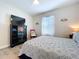 Bedroom with fan, tv, wood floors, and bright natural lighting at 3205 Royal Tern Dr, Winter Haven, FL 33881