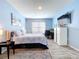 A modern bedroom featuring blue walls, a TV, workstation, and a comfortable bed with wood look flooring at 3205 Royal Tern Dr, Winter Haven, FL 33881
